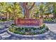 Beautifully landscaped entrance to The Springs community, featuring stone signage and mature trees at 6925 Emerald Springs Ln, Las Vegas, NV 89113