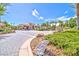 Grand driveway leading to a stunning entrance, complemented by lush landscaping and mature trees at 6925 Emerald Springs Ln, Las Vegas, NV 89113