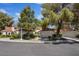 Charming townhomes with well-maintained landscaping and attached garages create a welcoming neighborhood street view at 6925 Emerald Springs Ln, Las Vegas, NV 89113