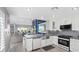 Bright kitchen with white cabinetry, stainless appliances, marble counters, and an open layout at 6925 Emerald Springs Ln, Las Vegas, NV 89113