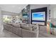 Modern living room with a vaulted ceiling, a fireplace, a television, and a large sectional couch at 6925 Emerald Springs Ln, Las Vegas, NV 89113