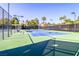 Well-maintained tennis court featuring a blue playing surface and a green perimeter within a gated area at 6925 Emerald Springs Ln, Las Vegas, NV 89113