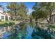 Scenic view of homes overlooking a tranquil canal with lush greenery and serene reflections at 6925 Emerald Springs Ln, Las Vegas, NV 89113