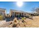 Spacious backyard with desert landscaping, a covered patio, and views of the neighboring homes at 7649 Broadwing Dr, North Las Vegas, NV 89084