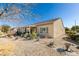 Exterior view of the backyard showcasing desert landscaping, a covered patio, and a window at 7649 Broadwing Dr, North Las Vegas, NV 89084