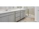 Modern bathroom with gray cabinets, double sinks, stylish tile floors, and a glass-enclosed shower at 77 Tardando Ave, Henderson, NV 89015