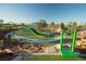 Playground with green cushioned ground, rock features, and a large twisting slide for community enjoyment at 77 Tardando Ave, Henderson, NV 89015