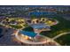 Aerial night view of community park, green space, and walking paths with the city skyline in distance at 77 Tardando St, Henderson, NV 89015