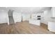 Open-concept living space with wood floors connecting the living area, kitchen, and staircase at 77 Tardando St, Henderson, NV 89015