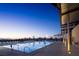Community pool at dusk with mountain views, lounge chairs, and lighting at 77 Tardando St, Henderson, NV 89015