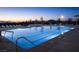 Beautifully lit community pool with lane lines and dusk scenery at 77 Tardando St, Henderson, NV 89015