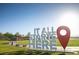 A vibrant community welcome sign surrounded by lush greenery and blue skies at 77 Tardando St, Henderson, NV 89015