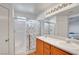 Bathroom featuring a double vanity, wood cabinets, and a shower with glass doors at 7721 Sour Gum Ct, Las Vegas, NV 89131