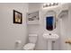 Charming powder room with pedestal sink, decorative shelving, and neutral wall color at 7721 Sour Gum Ct, Las Vegas, NV 89131
