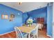 Bright dining area with wood floors, blue walls, seating for four, and adjacent living space at 7721 Sour Gum Ct, Las Vegas, NV 89131