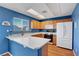 Kitchen with wood cabinets, white appliances, Corian countertops, blue walls and a breakfast bar at 7721 Sour Gum Ct, Las Vegas, NV 89131