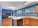 Bright kitchen featuring wood cabinets, a breakfast bar, and sliding glass doors leading to the backyard at 7721 Sour Gum Ct, Las Vegas, NV 89131