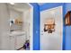 Laundry room with a washer and dryer and storage shelves on bright blue walls at 7721 Sour Gum Ct, Las Vegas, NV 89131