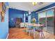 Open concept space with dining, living area, wood floors, blue walls and natural light at 7721 Sour Gum Ct, Las Vegas, NV 89131