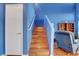 A view of wooden stairs with bright blue walls and white trim, with a glimpse of the living area at 7721 Sour Gum Ct, Las Vegas, NV 89131