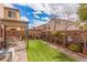 Picturesque backyard with artificial turf, a charming patio cover, and privacy brick wall with potted plants at 7769 Peaceful Trellis Dr, Las Vegas, NV 89179