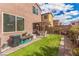 Landscaped backyard with artificial turf, a covered patio, and views of the neighborhood at 7769 Peaceful Trellis Dr, Las Vegas, NV 89179