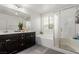 Bright bathroom featuring a double vanity, soaking tub, and glass-enclosed shower at 7769 Peaceful Trellis Dr, Las Vegas, NV 89179