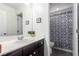 Well-lit bathroom featuring a modern sink and a shower with a patterned curtain at 7769 Peaceful Trellis Dr, Las Vegas, NV 89179