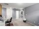 Bright bedroom hallway featuring neutral carpet and gray walls, plus a home office setup at 7769 Peaceful Trellis Dr, Las Vegas, NV 89179