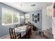 Bright dining room featuring tile floors, neutral walls, large windows, and a dining table with seating for eight at 7769 Peaceful Trellis Dr, Las Vegas, NV 89179