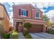 Two-story home features a two-car garage, manicured landscaping, a covered front entry, and close proximity to other homes at 7769 Peaceful Trellis Dr, Las Vegas, NV 89179