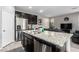 Well-lit kitchen featuring granite countertops, stainless steel appliances, dark cabinets, and functional kitchen island at 7769 Peaceful Trellis Dr, Las Vegas, NV 89179