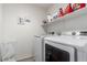 Functional laundry room with modern washer and dryer set and shelving at 7769 Peaceful Trellis Dr, Las Vegas, NV 89179