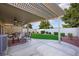 Inviting covered patio area with seating, a dining table, and a well-maintained artificial lawn at 7916 Nesting Pine Pl, Las Vegas, NV 89143