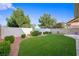 Green backyard featuring artificial turf, mature trees and shrubs, and a brick perimeter wall at 7916 Nesting Pine Pl, Las Vegas, NV 89143