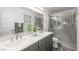 Bathroom featuring double sinks, gray cabinets, a plant, and a glass shower at 7916 Nesting Pine Pl, Las Vegas, NV 89143