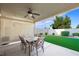 Outdoor dining area with a spacious table, chairs, ceiling fan, and view of the landscaped backyard at 7916 Nesting Pine Pl, Las Vegas, NV 89143