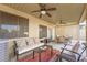 Covered patio with comfortable seating, a dining table, ceiling fans, and backyard access at 7916 Nesting Pine Pl, Las Vegas, NV 89143