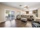 The living room boasts a large sectional couch, hardwood floors, a sliding door and adjoined kitchen at 7916 Nesting Pine Pl, Las Vegas, NV 89143