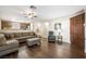 Open-concept living room with hardwood floors, sectional couch, fireplace, and adjacent kitchen at 7916 Nesting Pine Pl, Las Vegas, NV 89143
