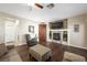 Comfortable living room features a fireplace, wood floors, sectional couch, and reading chair at 7916 Nesting Pine Pl, Las Vegas, NV 89143