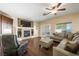 Cozy living room with fireplace, hardwood floors, sectional sofa and sliding glass doors at 7916 Nesting Pine Pl, Las Vegas, NV 89143