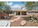 Desert landscaped backyard featuring a covered patio, fire pit, and stone pathway at 8316 Imperial Lakes St, Las Vegas, NV 89131