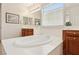 Bright bathroom with a large soaking tub, dual vanity, and natural light streaming through a window at 8316 Imperial Lakes St, Las Vegas, NV 89131
