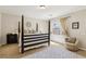 Bright bedroom with a four-poster bed, cozy seating area, and large window at 8316 Imperial Lakes St, Las Vegas, NV 89131