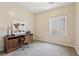 Neutral toned bedroom with a light color, large window, desk, and office chair at 8316 Imperial Lakes St, Las Vegas, NV 89131