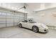 Spacious garage with a white sports car, side shelves, and an automatic garage door opener at 8316 Imperial Lakes St, Las Vegas, NV 89131