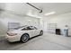 Clean, well-lit garage with a white sports car, metal shelving units, and epoxy flooring at 8316 Imperial Lakes St, Las Vegas, NV 89131