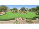 Exclusive community putting green with manicured turf, desert landscaping, and shaded seating area at 8316 Imperial Lakes St, Las Vegas, NV 89131