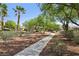 Serene walking path lined with desert landscaping, trees, and shrubs, creating a peaceful and inviting atmosphere at 8316 Imperial Lakes St, Las Vegas, NV 89131